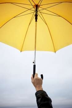 hand of man with yellow umbrella  selective focus on fingers (great abstract photo for many subjects)