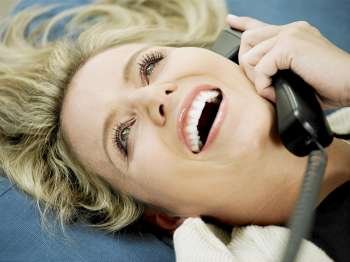 Close-up of a mid adult woman talking on the telephone and smiling