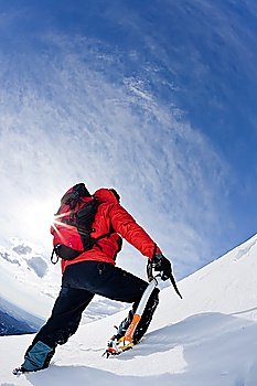 Mountaineer reaching the top of a snowcapped mountain peak Vertical frame