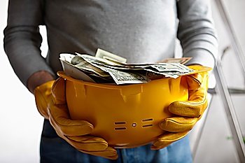 financial concept with dollars and yellow hardhat  selective focus on nearest part