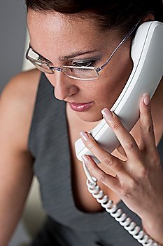 Successful executive businesswoman talking on the phone at office