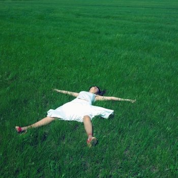 Portrait of cheerful young woman on a green field