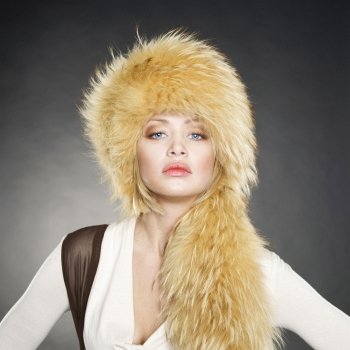 Fashion photo of beautiful young woman in a fur hat