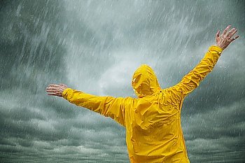 man in yellow coat enjoying the rain  selective focus