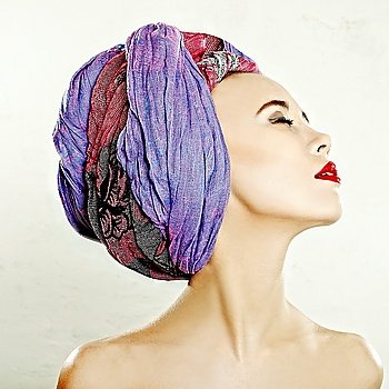 Closeup glamorous portrait of a young woman with decorative scarf on her head