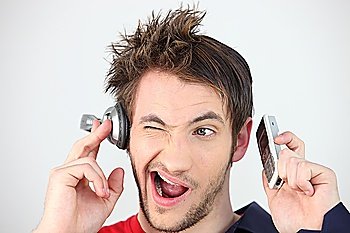 Man holding headphones and mobile telephone