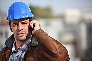 A construction foreman talking on his mobile phone