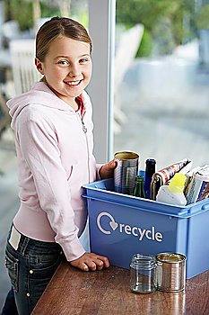 Girl (10-12) putting empty vessels into recycling container smiling side view