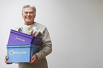 Middle-aged man holding recycling containers smiling
