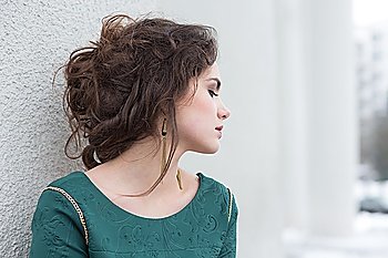 Romantic Caucasian Woman in Green Dress over White Wall outside Solitude