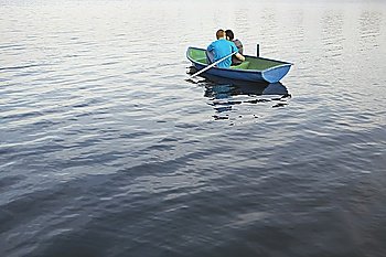 Young Couple Cuddling in Rowboat on Lake