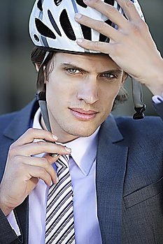 Portrait of young businessman adjusting helmet
