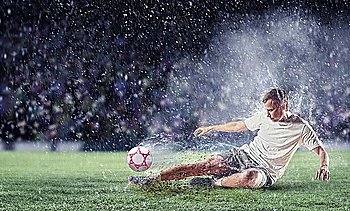 football player in white shirt striking the ball at the stadium under the rain