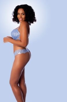 Beautiful happy sexy woman with curly hair in light blue lingerie