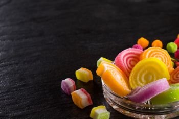 Colorful candies  jelly and marmalade and jellybeans around a central copy space on slate on background Top view with copy space