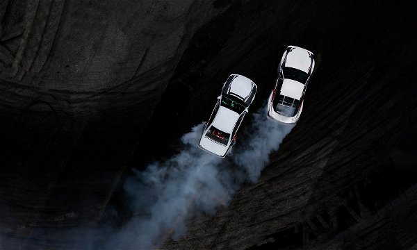 Aerial top view car drifting on asphalt race track with start and finish  line and lots of smoke from burning tires, Auto or automobile background  concept. Stock Photo