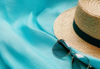Summer straw hat and sunglasses Blue summer vacation background Created with generative Ai technology