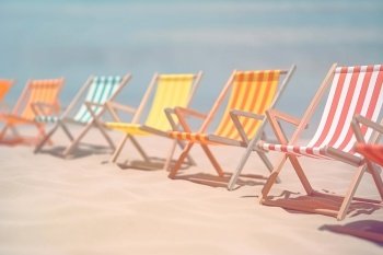 Multicolored beach chairs on sand beach Summer vacation concept background with copy space Created with generative Ai technology