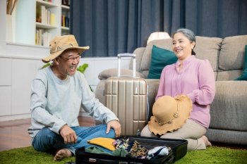Asian couple old senior marry retired prepare luggage suitcase arranging for travel  Romantic retired couple packing clothes travel bag suitcase toget