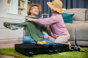 Asian couple old senior marry retired couple prepare luggage suitcase arranging for travel  Romantic retired couple packing clothes travel bag suitcas