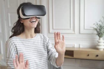 Young excited woman wearing 3d goggles interacting with augmented world  amazed female in VR headset playing games or making purchases in virtual real