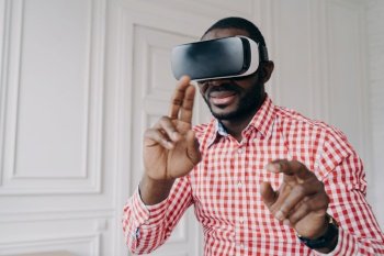 African man immersed in VR gaming at home  using virtual reality technology for business in modern office