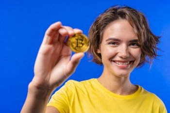 Woman with bitcoin  crypto currency Golden coin on blue background Digital exchange  popularity of BTC  symbol of future money  electronics industry