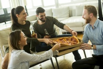 Young people eating pizza  drinking cider and have fun the room