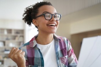 Excited african american teen girl in glasses feels happiness  received good news Biracial female student celebrate victory  enjoy success  personal 