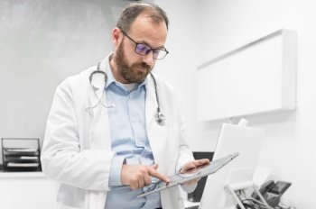 Male doctor with white coat and stethoscope using tablet  network connection in hospital room  Medical technology network concept High quality photog