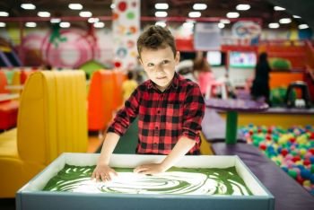Young boy draws in the sand  attraction in entertainment center Happy childhood Adventure time
