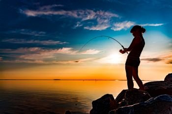 Woman fishing on Fishing rod spinning in Norway Fishing in Norway is a way to embrace the local lifestyle Countless lakes and rivers and an extensiv