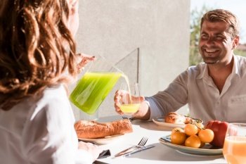Featuring a woman and man enjoying a wholesome breakfast together Seated at a cosy table with fresh fruits and juice  sharing smiles and lively conve