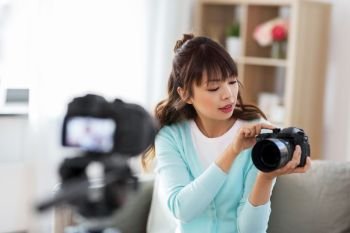 blogging  videoblog and technology concept - asian woman or blogger with photo camera recording video blog at home asian female blogger with camera r