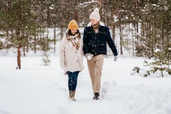 people  love and leisure concept - happy smiling couple walking in winter forest happy smiling couple walking in winter forest