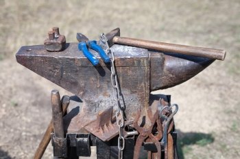 old anvil with many blacksmith tools
