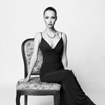 Black and white portrait of beautiful lady in luxury armchair