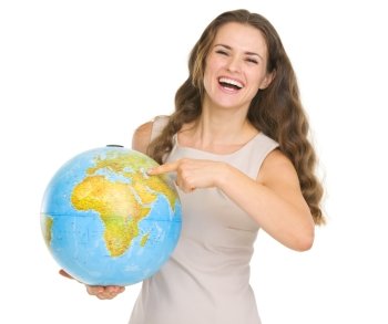 Smiling young woman pointing on globe