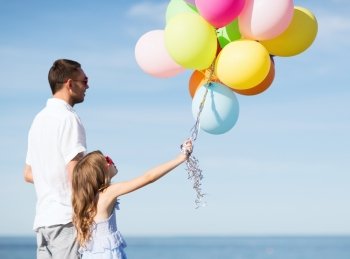 summer holidays  celebration  children and family concept - father and daughter with colorful balloons