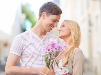 summer holidays  love  relationship and dating concept - couple with bouquet of flowers in the city