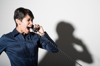A businesswoman shouting on the telephone