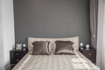 Bright  modern bedroom with beige bedspread