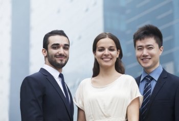 Portrait of three smiling business people  outdoors  business district
