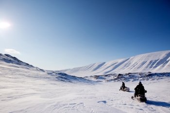 Two snowmobiles on a barren winter landscape  Svalbard Norway