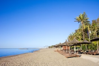 Sun loungers on a sandy beach by the Mediterranean Sea at the popular resort of Marbella in southern Spain  Costa del Sol  Andalusia region  Malaga pr