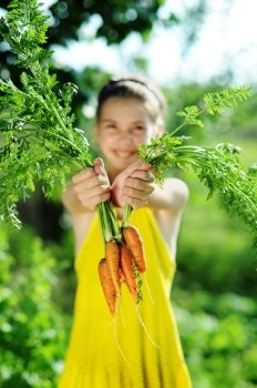 An image of a little girl with orange carrots