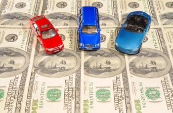 Three Toy Cars On One Hundred Dollar Bills