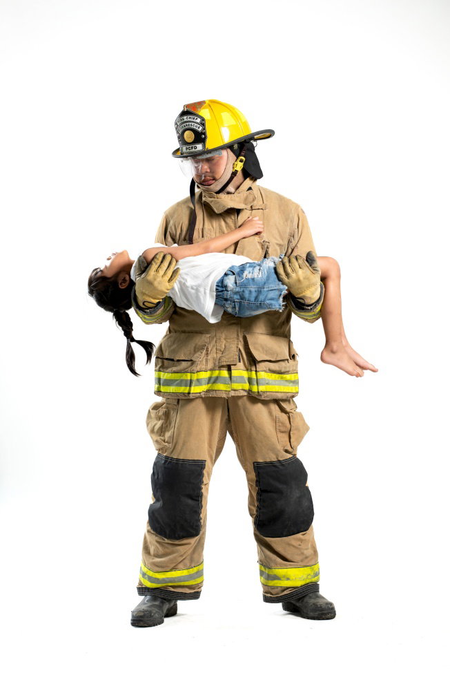 A firefighter in protective gear carries a young child to safety against a clean white background The image highlights protection rescue compassion A firefighter in protective gear carries a young child to safety against a clean white background The image highlights protection rescue compassion