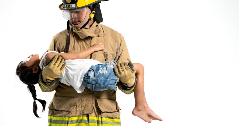 A firefighter in protective gear carries a young child to safety against a clean white background The image highlights protection rescue compassion A firefighter in protective gear carries a young child to safety against a clean white background The image highlights protection rescue compassion