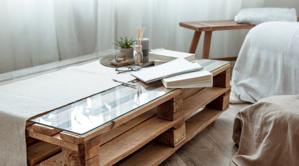 Close up of a wooden table with books in a room in a scandinavian style Part of the interior of a cozy room with a small table with books Close up of a wooden table with books in a room in a scandinavian style Part of the interior of a cozy room with a small table with books